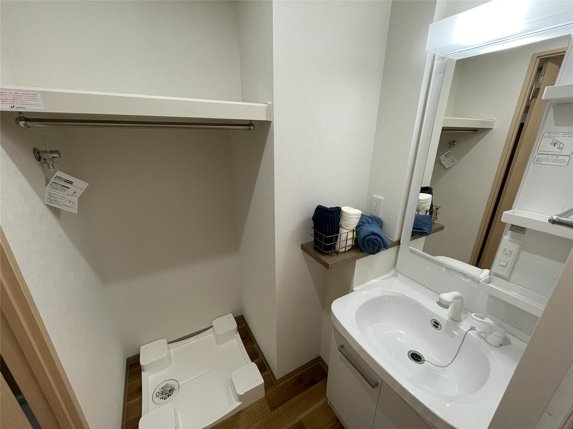 洗面設備　洗濯機置場上部棚にはハンガーバーがあります