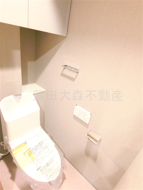 トイレ　棚収納に温水洗浄便座付きのトイレ
