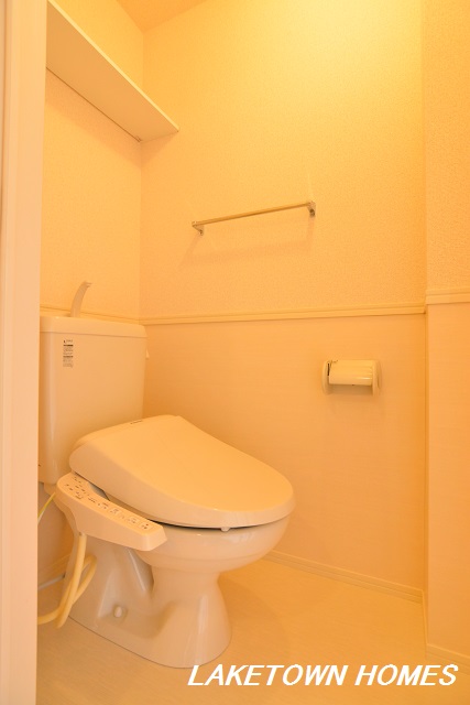 トイレ　上部に収納棚のある温水洗浄便座付のトイレです。