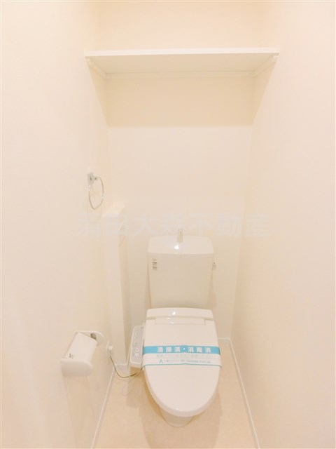 トイレ　棚と温水洗浄便座付のトイレ