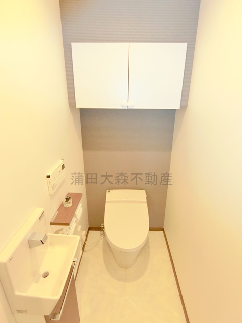 トイレ　吊戸棚収納と温水洗浄便座付きのタンクレストイレ