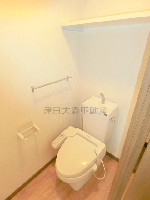 トイレ　棚と温水洗浄便座付きのトイレ