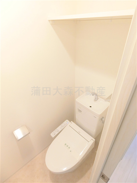 トイレ　棚と温水洗浄便座付きのトイレ