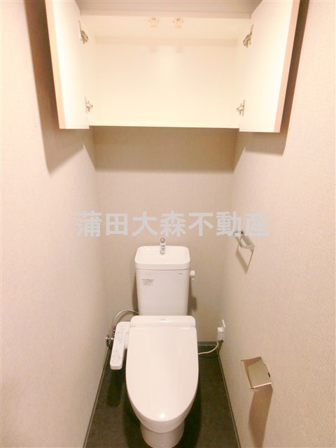 トイレ　吊戸棚と温水洗浄便座付きのトイレ
