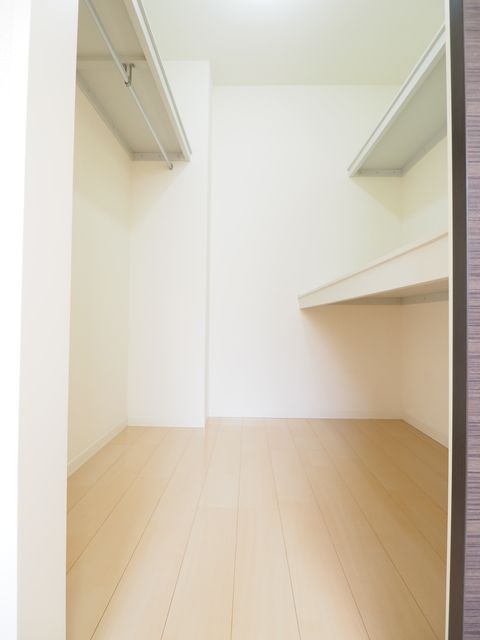 収納　ハンガーパイプと机棚を配したウォークインクローゼット