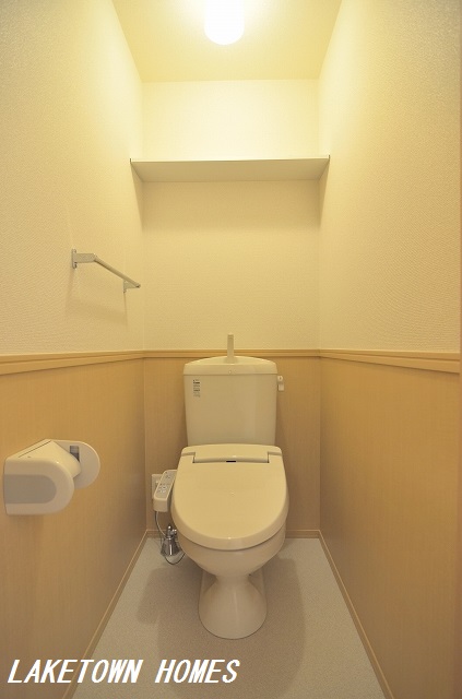 トイレ　上部に収納棚のある温水洗浄便座付のトイレです。
