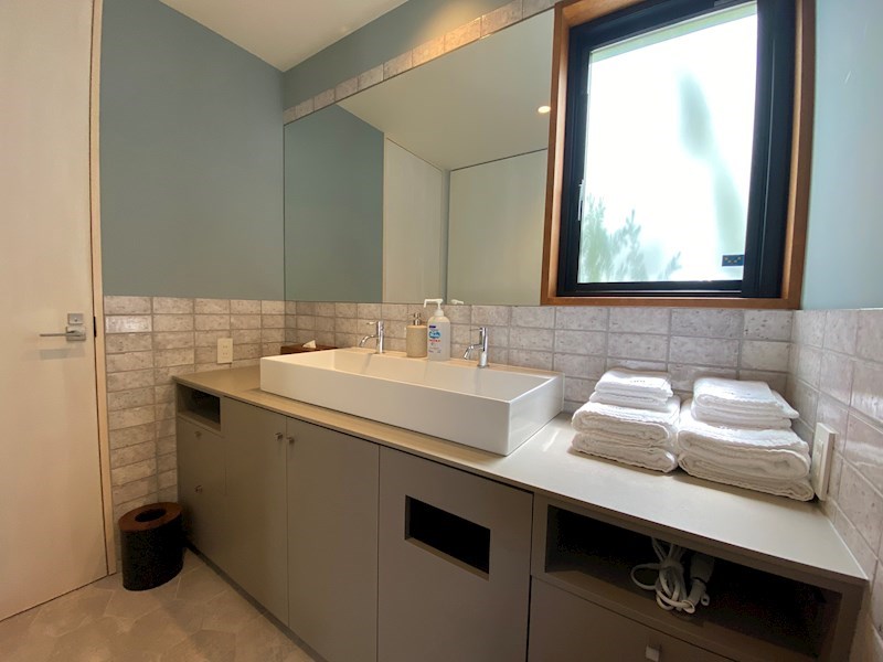 洗面設備　二人並んで使えるほどゆとりのあるカウンターと、壁一面の大きな