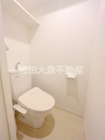トイレ　棚と温水洗浄便座付きのトイレ