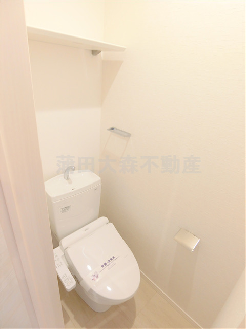 トイレ　棚と温水洗浄便座付きのトイレ