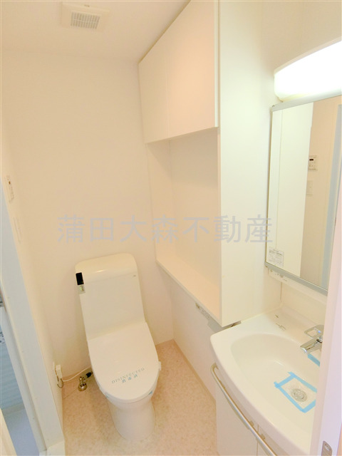 トイレ　棚と温水洗浄便座付きのトイレ