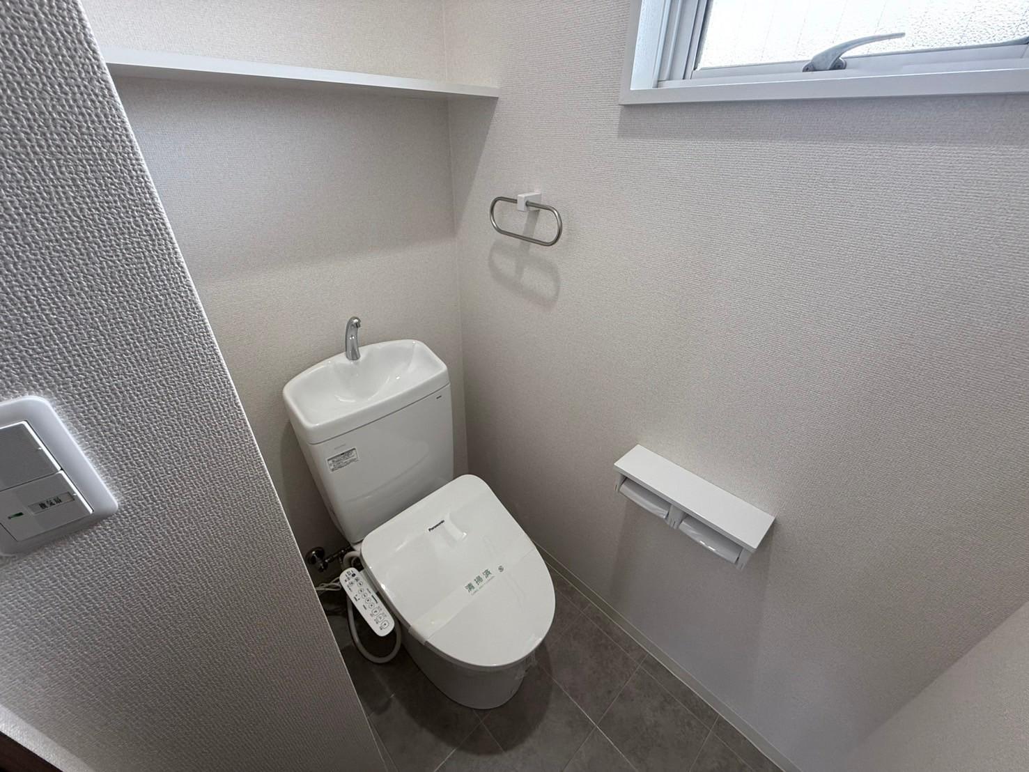 トイレ　収納棚付きの温水洗浄便座付きトイレです