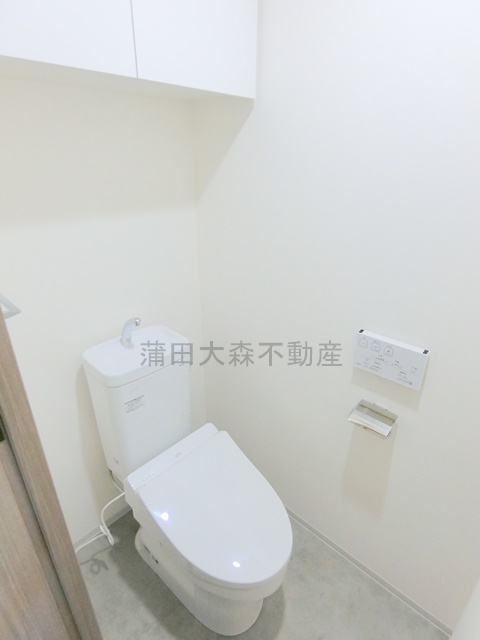 トイレ　棚収納と温水洗浄便座付きのトイレ