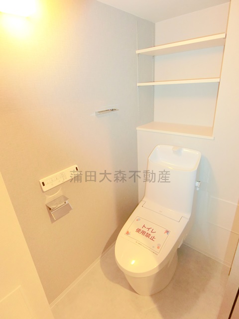 トイレ　棚と温水洗浄便座付きのトイレ