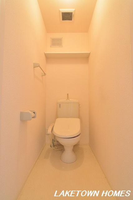 トイレ　上部に収納棚のある温水洗浄便座付のトイレです。