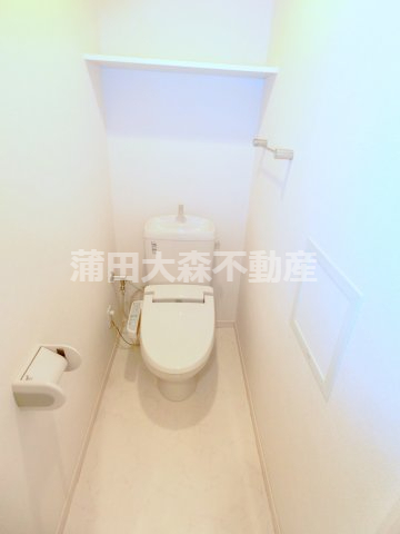 トイレ　棚と温水洗浄便座付きのトイレ