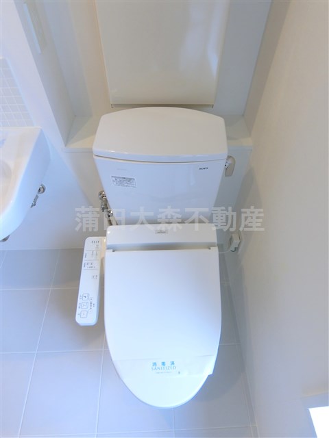 トイレ　棚と温水洗浄便座付きのトイレ