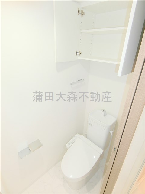 トイレ　吊戸棚収納と温水洗浄便座付きのトイレ