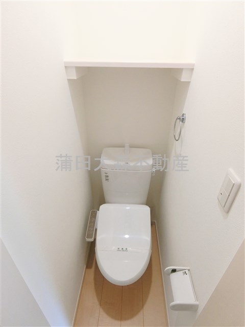 トイレ　棚と温水洗浄便座付きのトイレ
