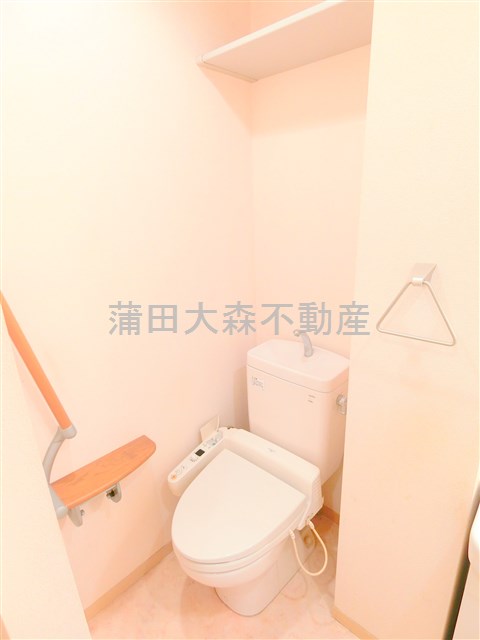 トイレ　上部棚と温水洗浄暖房便座付きのトイレ