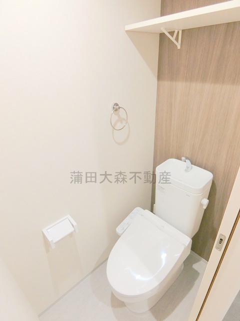 トイレ　棚と温水洗浄便座付きのトイレ