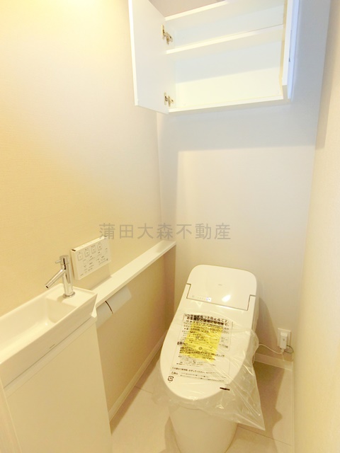 トイレ　棚と温水洗浄便座付きのトイレ