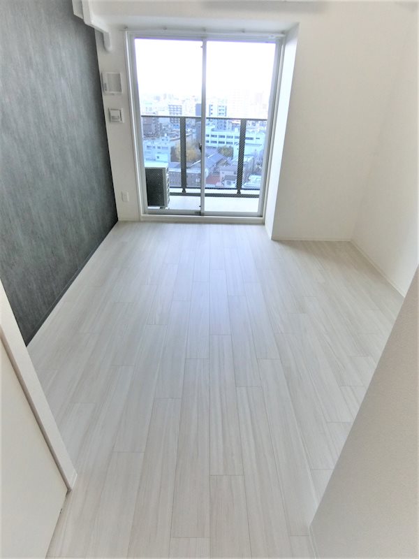 居室・リビング　西陽に照れされ、白のフローリング、アクセントクロスで落ち着い