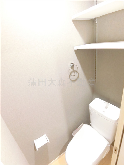 トイレ　棚と温水洗浄便座付きのトイレ
