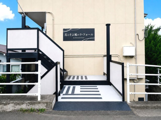 建物外観　カフェのようなデザイン看板が温かくお出迎え！