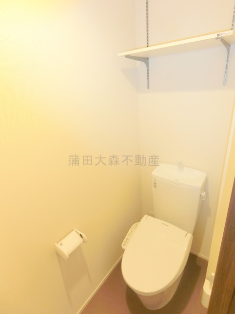 トイレ　棚と温水洗浄暖房便座付きのトイレ