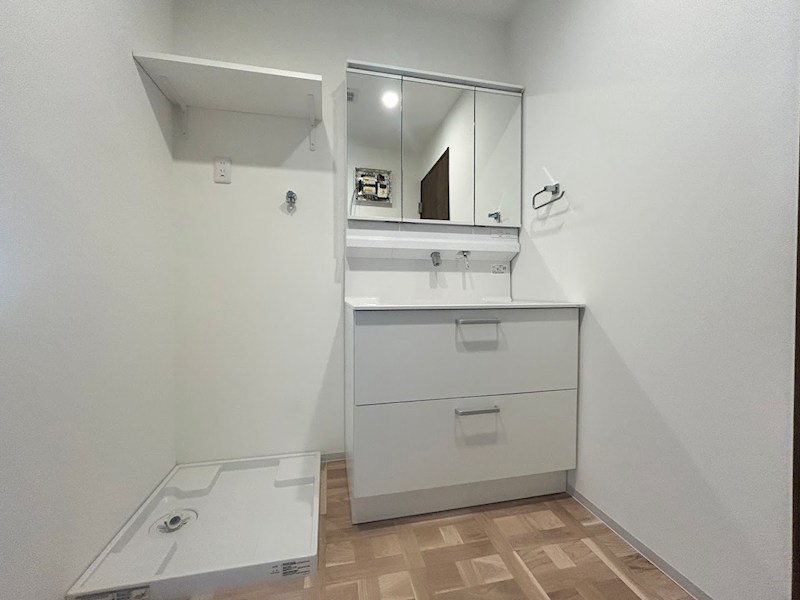 洗面設備　：　バスルームに続く広々とした洗面脱衣所