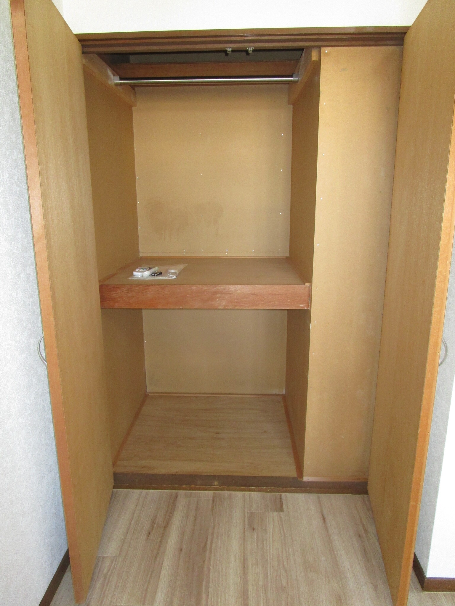 収納　洋間の収納スペースには服をかけることができる金具付です