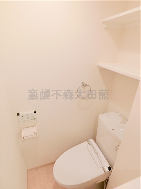 トイレ　棚と温水洗浄便座付きのトイレ