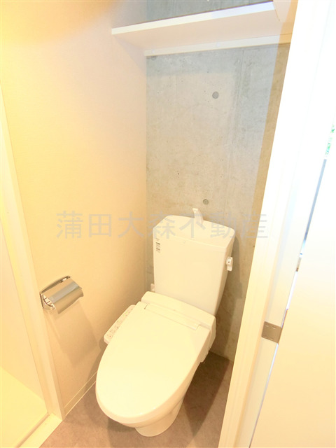 トイレ　棚と温水洗浄便座付きのトイレ