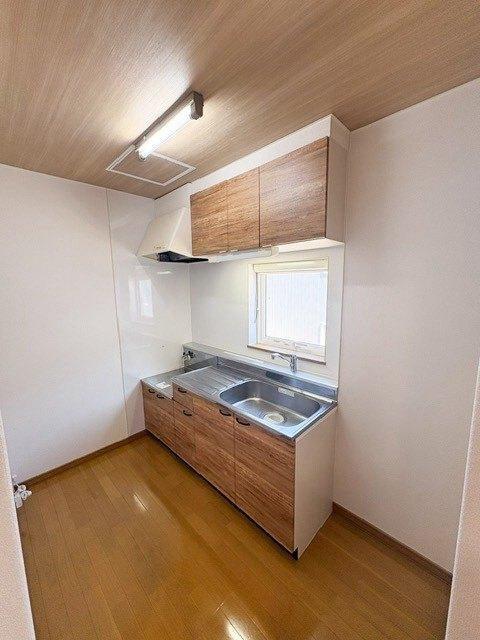 キッチン　リビングとひとつづきのキッチン。天井と収納扉は木目調に新調。