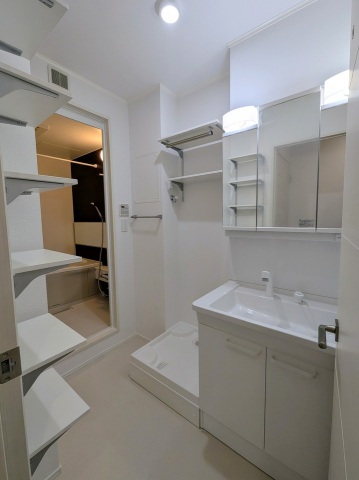 洗面設備　同ハウスメーカー施工例。洗面化粧台と洗濯機置き場、収納棚付き