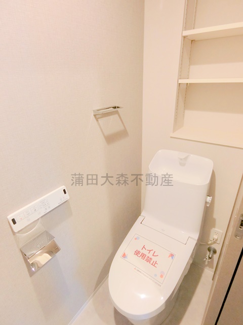 トイレ　棚と温水洗浄便座付きのトイレ