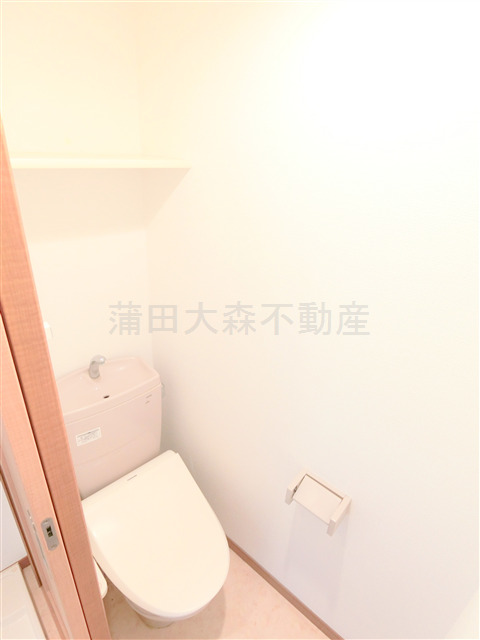 トイレ　棚と温水洗浄便座付きのトイレ