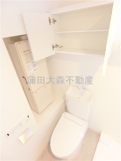 トイレ　吊戸棚と温水洗浄便座付きのトイレ