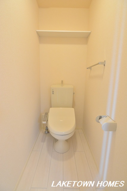 トイレ　上部に収納棚のある温水洗浄便座付のトイレです。