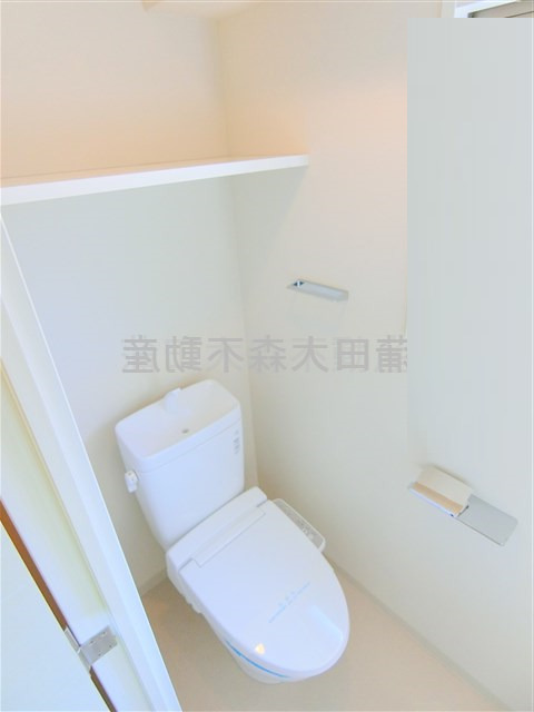 トイレ　棚と温水洗浄便座付きのトイレ