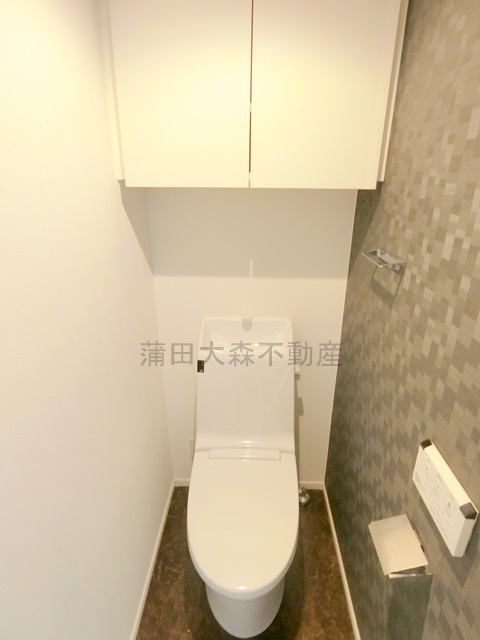 トイレ　吊戸棚収納と温水洗浄便座付きのトイレ