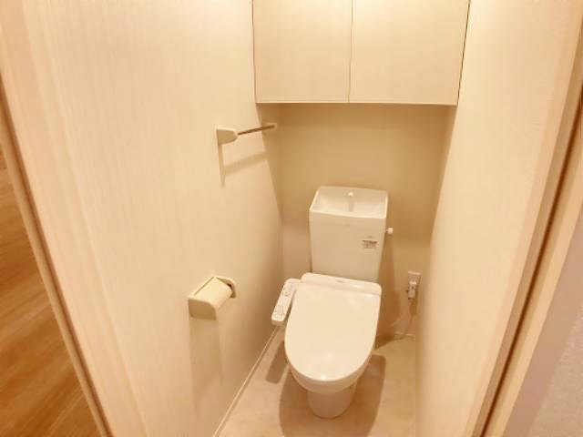 トイレ　上部収納、タオル掛けのある温水洗浄便座付きのトイレです。