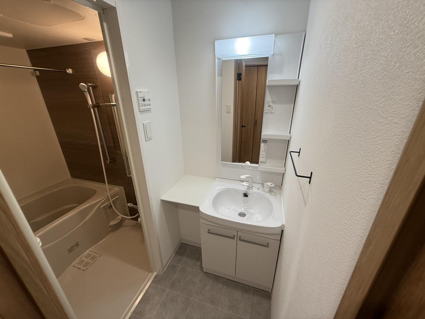 洗面設備　洗面台の横に棚があり身支度の際にも役立ちます