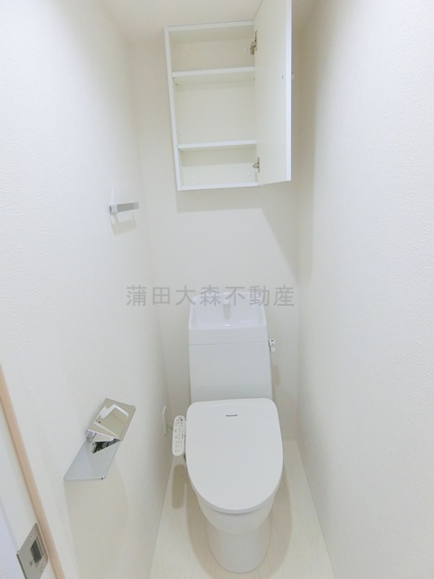 トイレ　吊り戸棚収納と温水洗浄便座付きのトイレ