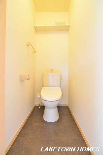 トイレ　上部に収納棚がある温水洗浄暖房便座付のトイレです。