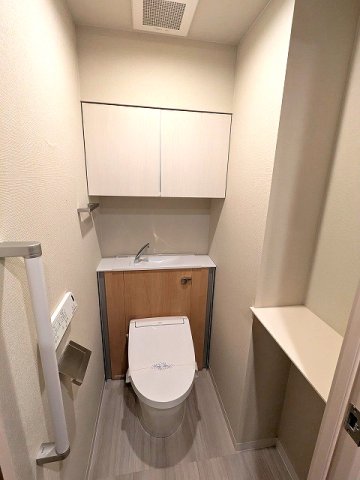 トイレ　瀟洒で節水効果あるタンクレス温水洗浄便座、棚付きです