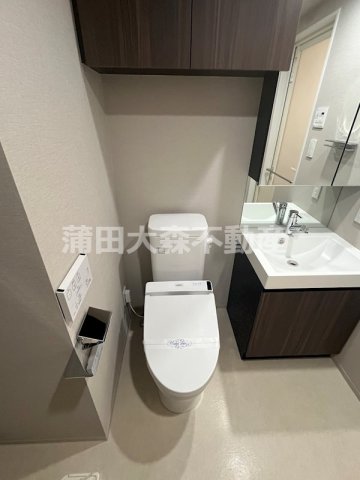 トイレ　吊戸棚と温水洗浄便座付きのトイレ
