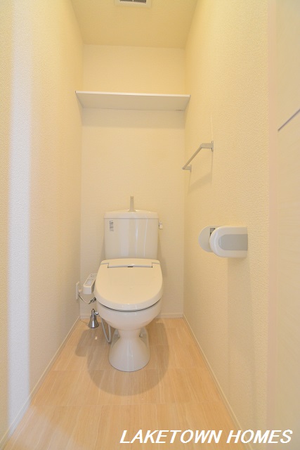 トイレ　上部に収納棚がある温水洗浄暖房便座付のトイレです。