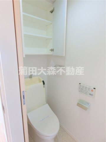 トイレ　吊戸棚収納と温水洗浄便座付きのトイレ