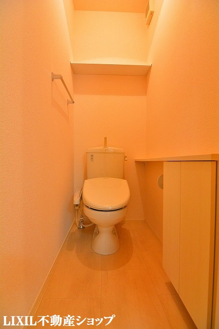 トイレ　収納棚がある温水洗浄暖房便座のトイレです。